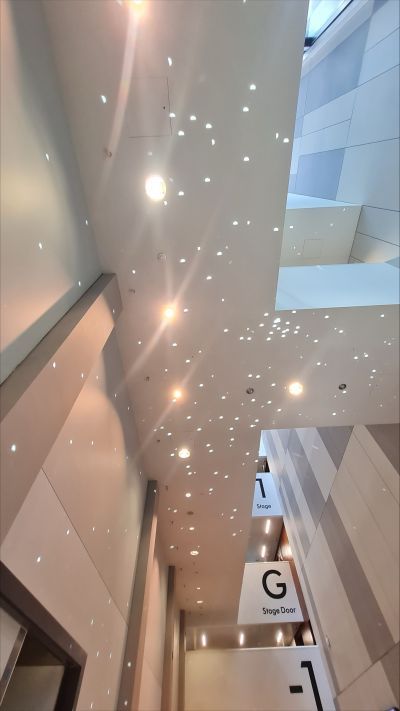 Inside Milton Court theatre showing sign for the stage door with twinkly lights on the walls