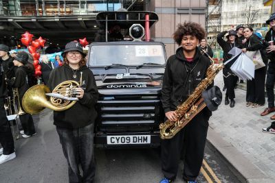 Two brass percussionists in front of DJ truck in procession for Lady Mayors Show