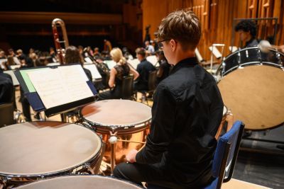 Young boy playing percussion, taken from the back