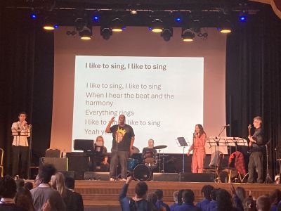 Band singing along to lyrics on stage