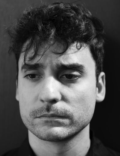 Black and white image of a white man with short dark hair