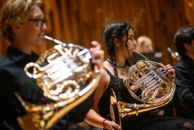 Two young musicians play the french horn in Barbican Hall