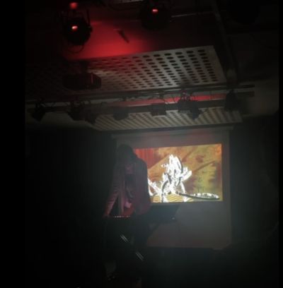 Videvittu image of a dark hall with a projection