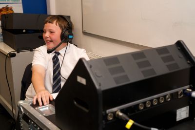 School boy enjoying using a theatre prompt desk