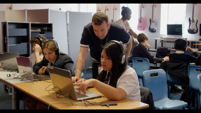 Roadshow facilitator instructs school pupils on QLab software
